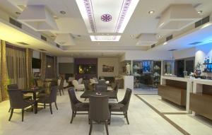 a restaurant with tables and chairs in a room at Arty Grand Hotel in Olympia