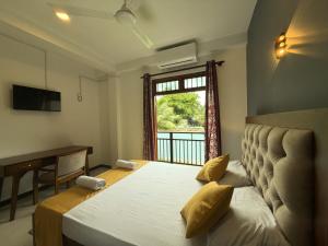 a bedroom with a bed with a window and a desk at Hotel Dreamliners in Katunayaka