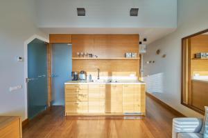 a kitchen with a sink and wooden cabinets at Visit Nida Apartments in Nida