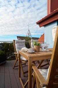a wooden table and chairs on a deck with a view at Visit Nida Apartments in Nida +30 photos