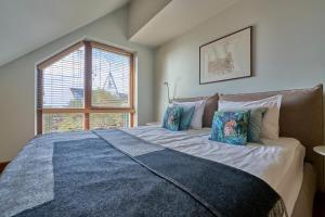 a large bed in a room with a window at Visit Nida Apartments in Nida