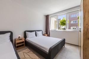 a bedroom with two beds and a window at Le Bleu Apartment Pool & Beach by PikHost in Lezhë +22 photos