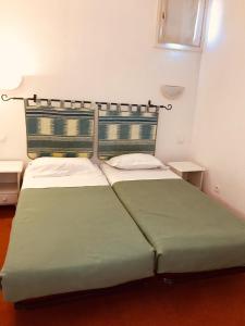 a bedroom with a green bed with two pillows at Lagrange Vacances Résidence du Golf in Saint-Cyprien