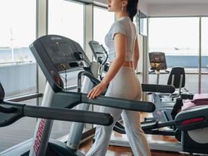a woman walking on a treadmill in a gym at Novotel Istanbul Zeytinburnu in Istanbul