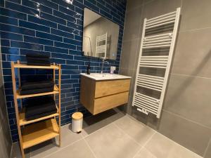 a blue tiled bathroom with a sink and a mirror at B&B Historia in Melderslo +20 photos