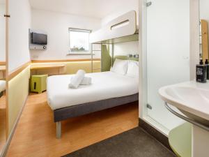 a hotel room with a bed and a sink at ibis budget Sheffield Arena in Sheffield