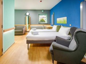a hotel room with a bed and a couch at ibis budget Sheffield Arena in Sheffield +62 photos