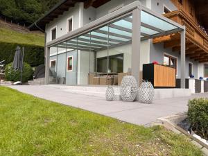 a house with glass doors on a sidewalk at Unterbleiwanghof in Radstadt +1 photo