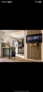 a living room with a kitchen with a tv on the wall at JenAlya in Vallauris