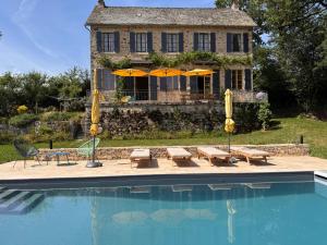 a house with a swimming pool in front of a house at Le Couvent in Lunac