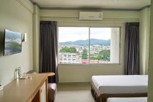a hotel room with a bed and a large window at Yala Rama Hotel in Sathani Yala