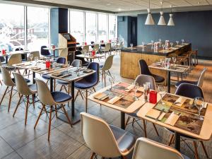 a restaurant with tables and chairs and a bar at ibis London Elstree Borehamwood in Borehamwood