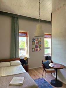 a bedroom with a bed and a table and a chair at Hotel Suonenjoki in Suonenjoki