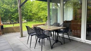 a table and chairs sitting on a screened porch at De Zandzegge | 4 persons in Gasselte