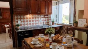 a kitchen with a table with a bowl of bread at Zia Peppina in Tertenìa