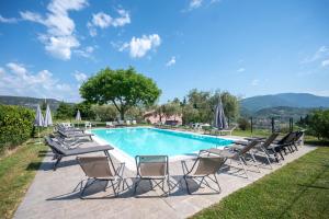 a pool with chaise lounge chairs and a table and a group ofvationvation at ApartmentsGarda - Ca' Capre in Garda