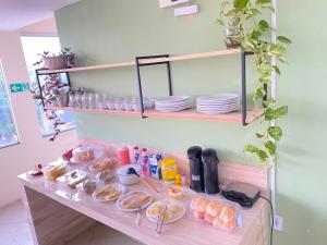 a table with plates and food on it at Hotel Renascer pojuca in Pojuca