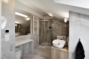 a bathroom with a shower and a sink at Apartamenty Rondo in Świnoujście
