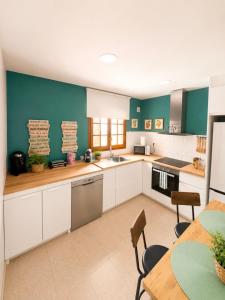 a kitchen with white cabinets and a table with chairs at MARSOL RELAX Roda de Barà in Roda de Bará