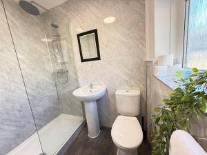 a bathroom with a toilet and a sink and a shower at SPACIOUS 3 BEDROOM HOUSE WITH FREE STREET PARKING and WIFI IDEAL FOR CONTRACTORS by NORTH WEST ACCOMMODATION in Saint Helens +9 photos