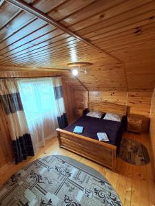 a bedroom with a bed in a wooden cabin at На Пагорбі in Mykulychyn