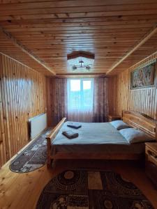 a bedroom with a large bed in a wooden room at На Пагорбі in Mykulychyn