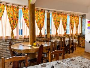a restaurant with wooden tables and chairs and windows at Pousada Wilclé Center Preá in Prea