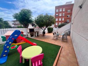 a patio with a playground with a table and chairs at MARSOL RELAX Roda de Barà in Roda de Bará