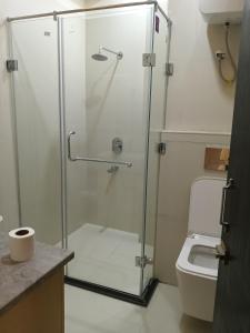 a shower stall in a bathroom with a toilet at Borbon Hotel & Restaurant in Jowai +6 photos