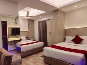 a hotel room with two beds and a tv at Arham Beach Resort in Cox's Bazar