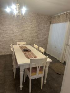 a white dining room table with chairs and a chandelier at Aer in Caserta