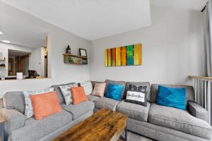a living room with a gray couch with colorful pillows at Decatur #1797 in Keystone