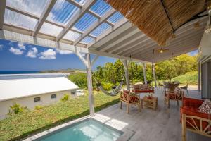 a patio with a pool and a table and chairs at La Villa de Solange - Canope in La Trinité