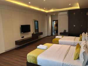 a hotel room with two beds and a flat screen tv at Borbon Hotel & Restaurant in Jowai