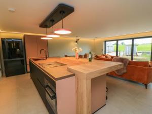 a kitchen with a kitchen island in a room at The Cozie Sow in Yeovil