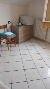 a kitchen with a table and a chair and a tiled floor at affittacamere marosa in Albenga