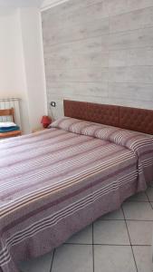 a large bed sitting in a room with a wall at affittacamere marosa in Albenga