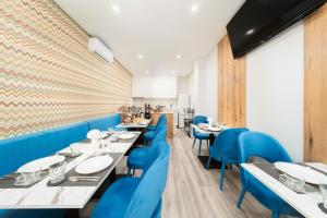 a dining room with blue chairs and tables at Guesthouse Solar do Mar in Silveira