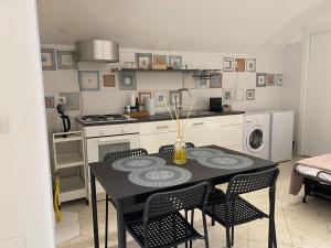 a kitchen with a black table and chairs in a room at Casa Porsia in Altamura