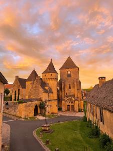 an old castle with a sunset in the background at Maison Honorine in Saint-Geniès