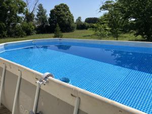 a swimming pool with blue tiles on a fence at Gite de Saint Jean in Saint-Jean-de-Thouars