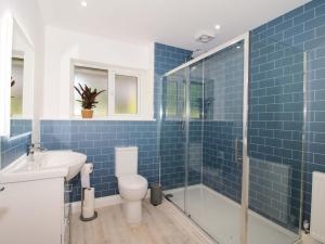 a blue tiled bathroom with a toilet and a sink at Westington Hall in Leominster +36 photos