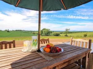 a plate of fruit on a wooden table under an umbrella at Westington Hall in Leominster