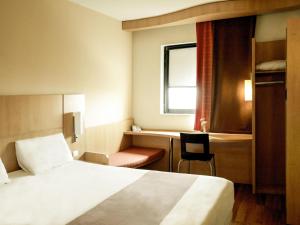 a hotel room with a bed and a chair and a window at Ibis Constantine in Constantine +58 photos