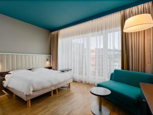 a hotel room with a bed and a couch at Park Inn by Radisson Central Tallinn in Tallinn