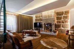a living room with a couch and a fireplace at Casas da Aldeia da Graça in Guimarães