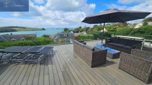 a patio with tables and chairs and an umbrella at Highlands in Saint Mawes