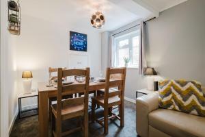 a dining room with a table and chairs and a couch at Spacious 4-Bed Home with Free Parking in Northampton
