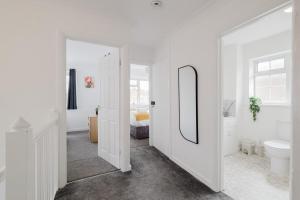 a white bathroom with a sink and a mirror at Spacious 4-Bed Home with Free Parking in Northampton +61 photos