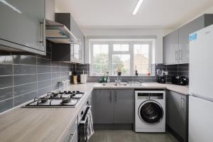 a kitchen with a washer and dryer in it at Spacious 4-Bed Home with Free Parking in Northampton